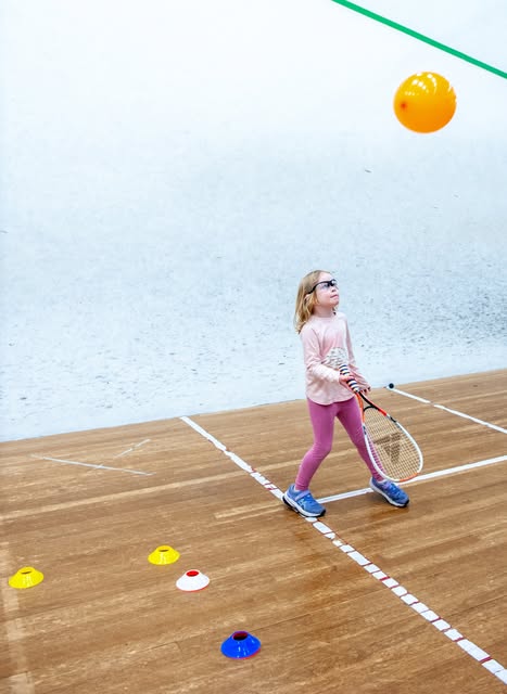 Young player hitting balloon on court