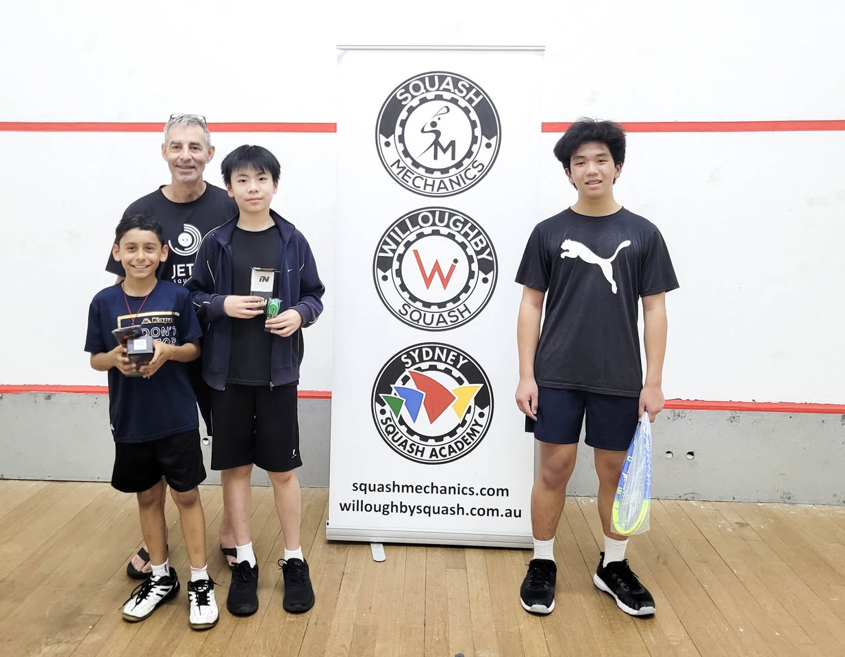 Coach Geoff with junior players and trophies